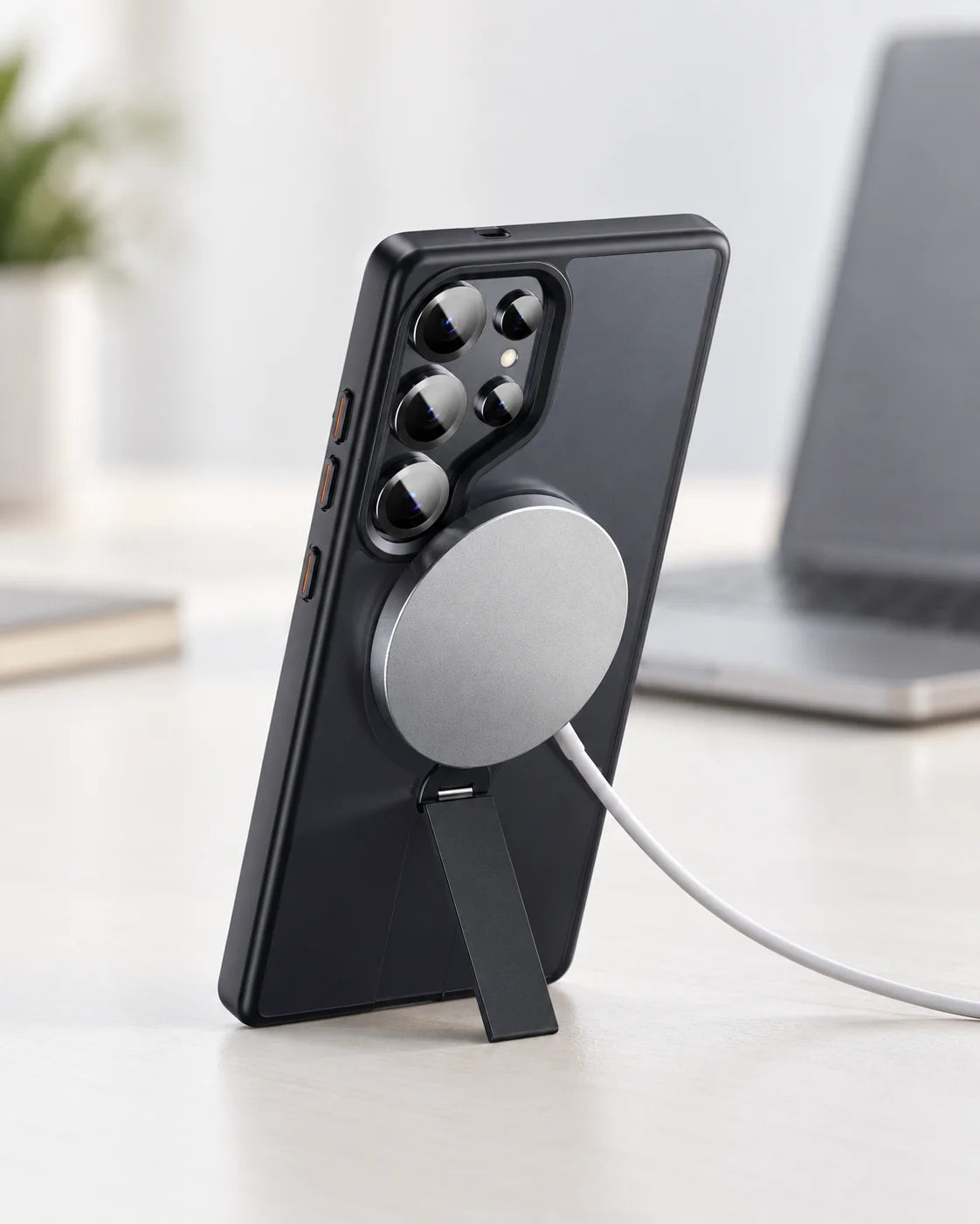 Black phone case standing on its folding arm with a magnetic charging puck attached #Samsung Model_Samsung S25 Ultra