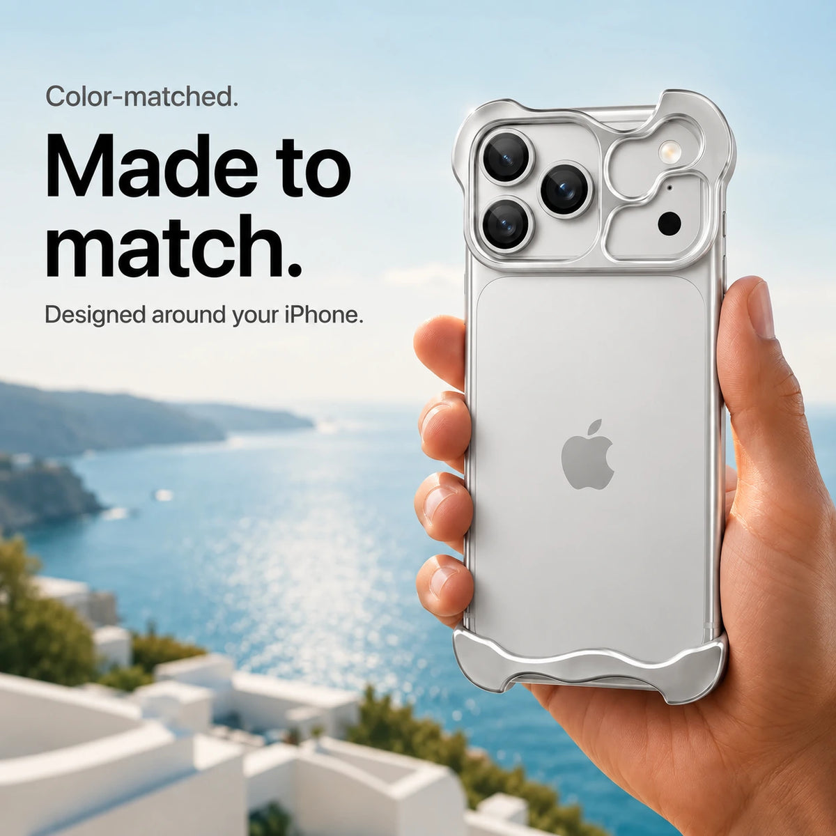 Silver sculpted metal phone case held in a hand above a coastal background #color_Titanium Silver